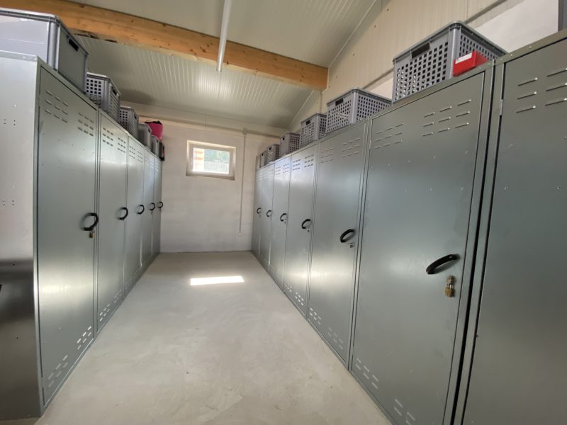 Ein zentraler Aspekt: Die Sattelkammer! Blick in eine Sattelkammer, an beiden Seiten des Gangs stehen Sattelschränke aufgereiht.